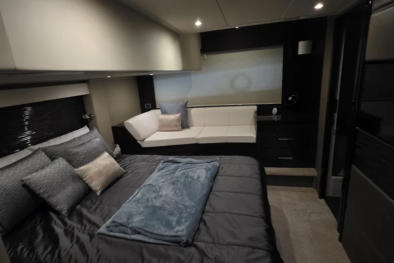 Slide: The Image of Luxurious interior of 2018 Carver C52 Coupe yacht bedroom with elegant bedding and seating area. - 49