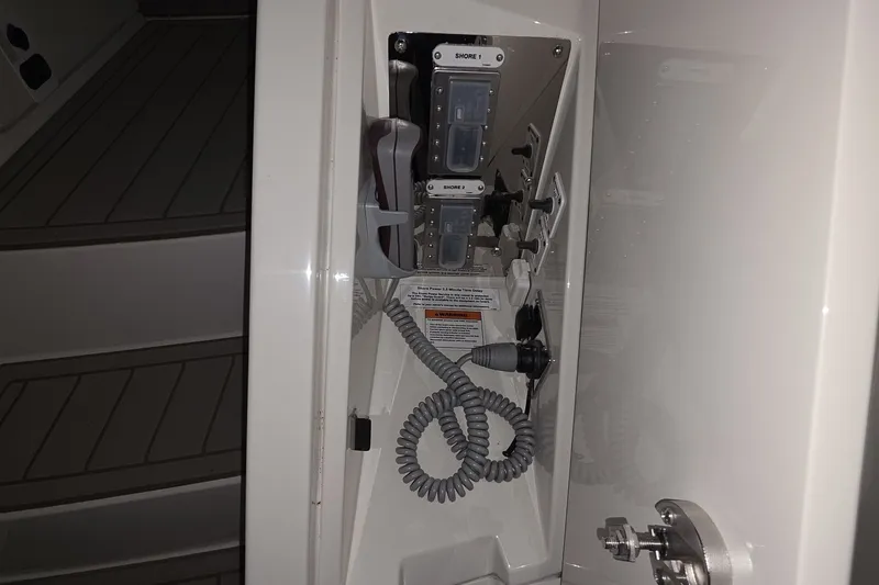 Slide: The Image of Electrical panel inside 2018 Carver C52 Coupe yacht, featuring shore power connections. - 39