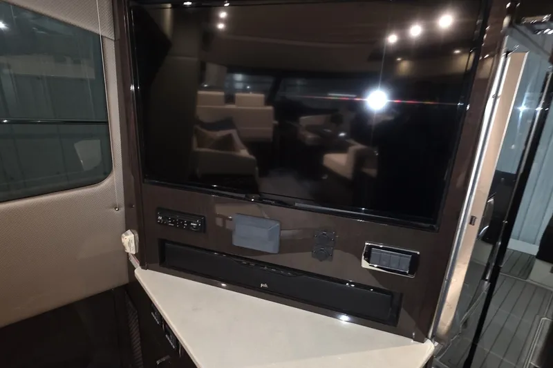 Slide: The Image of Interior of 2018 Carver C52 Coupe featuring a mounted flat-screen TV and sound system. - 38