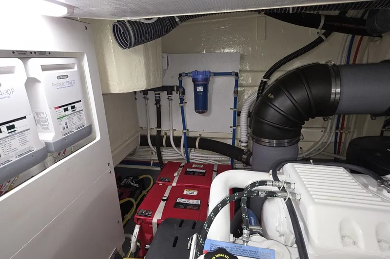 Slide: The Image of Engine room of a 2018 Carver C52 Coupe with batteries and electrical systems. - 55