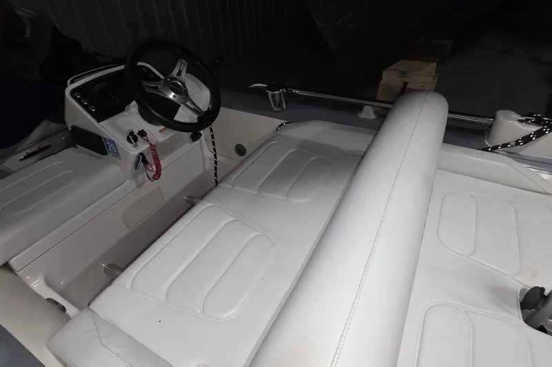 Slide: The Image of Interior of a 2018 Carver C52 Coupe boat with white seating and steering wheel. - 68