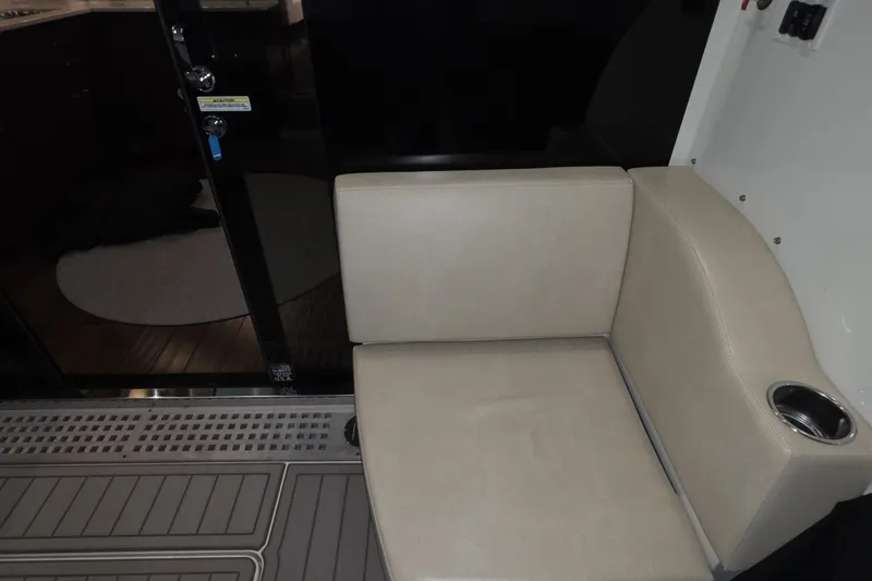 Slide: The Image of Beige seating area inside 2018 Carver C52 Coupe with cup holder and sleek design. - 28