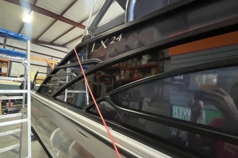 Slide: The Image of 2023 Bennington 24 LXS Swingback pontoon boat in a workshop setting. - 6