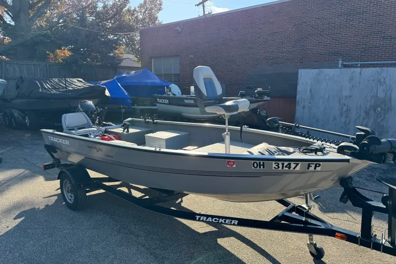 The Image of 2013 Tracker Super Guide V-16 DLX T fishing boat on trailer in outdoor setting. - 0