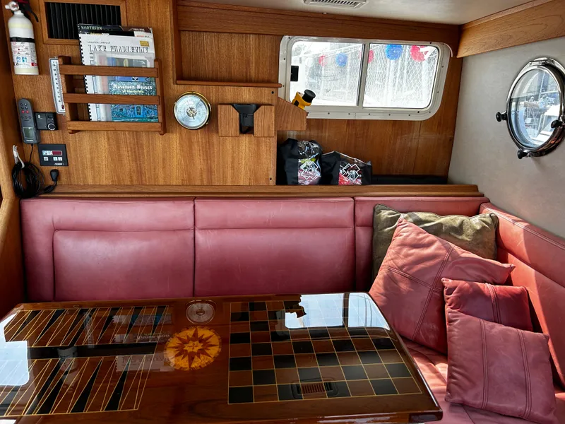 Slide: The Image of Cozy interior of 2003 Nordic Tug 52 with red seating and decorative pillows. - 30