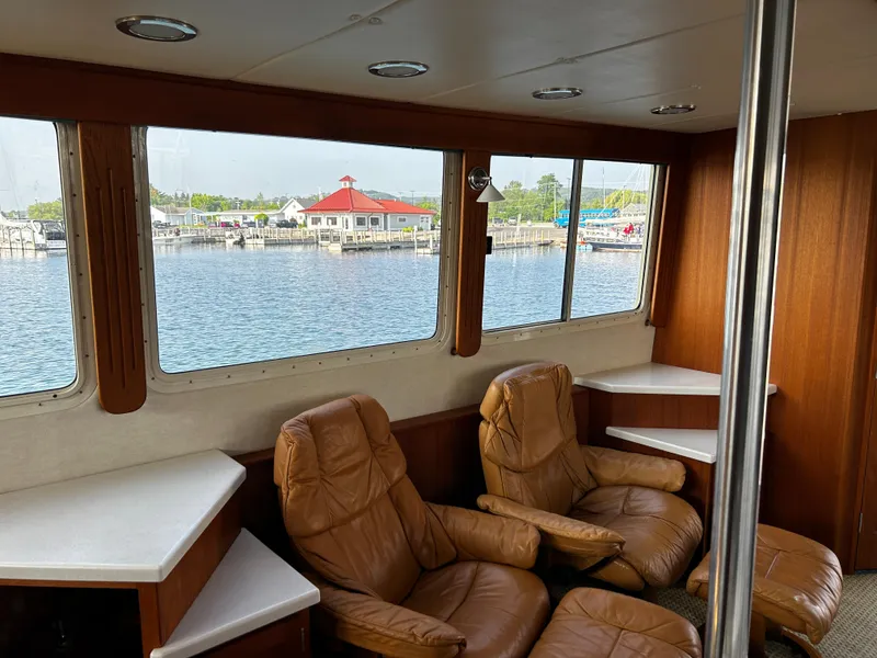 Slide: The Image of Interior of 2003 Nordic Tug 52 with leather chairs and waterfront view. - 36