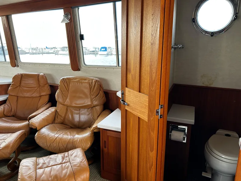 Slide: The Image of Interior of 2003 Nordic Tug 52 with leather chairs and a compact bathroom. - 37