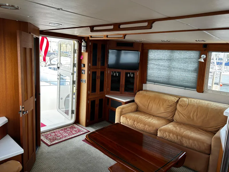 Slide: The Image of 2003 Nordic Tug 52 interior with beige sofa, wooden table, and TV. - 39