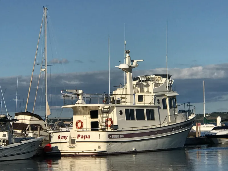 Slide: The Image of 2003 Nordic Tug 52 boat docked at marina under clear sky. - 4