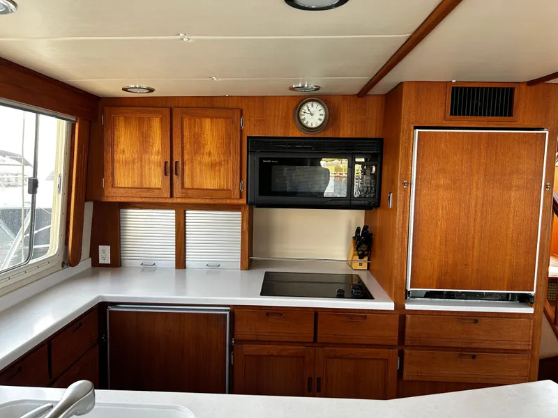 Slide: The Image of Kitchen area of a 2003 Nordic Tug 52 with wooden cabinets and modern appliances. - 42