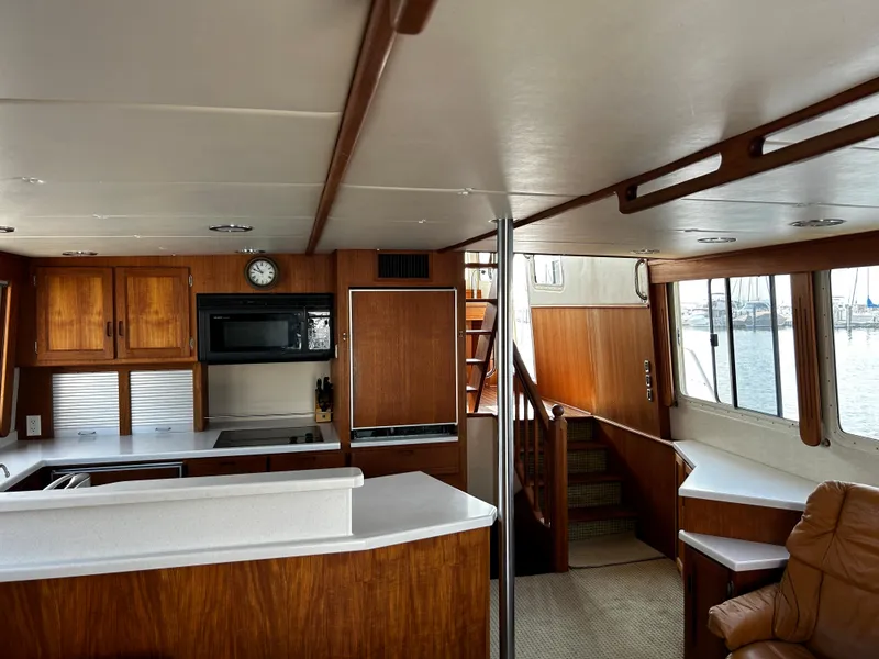 Slide: The Image of Interior of 2003 Nordic Tug 52, featuring a cozy kitchen and seating area with wood finishes. - 43