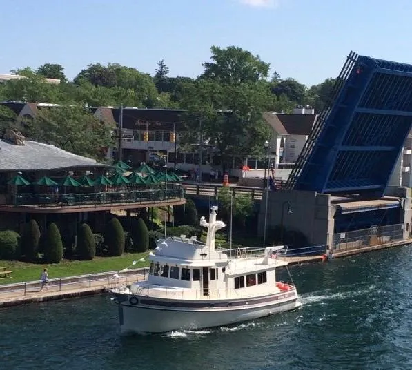 Slide: The Image of 2003 Nordic Tug 52 passing under a raised drawbridge near a waterfront restaurant. - 6
