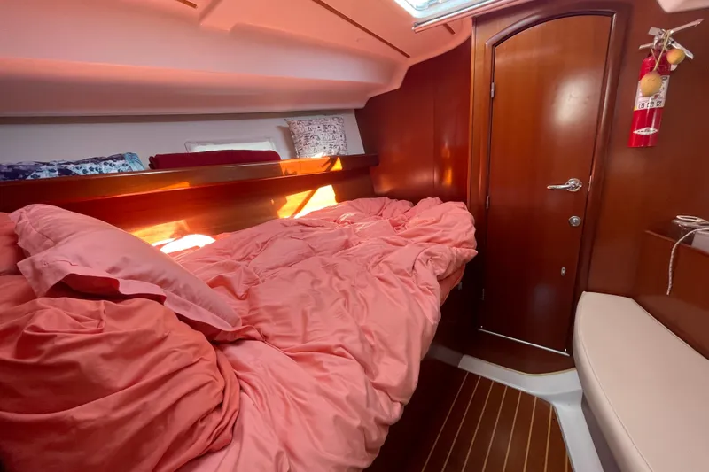 Slide: The Image of Cozy cabin interior of 2007 Beneteau 393 sailboat with pink bedding and wooden accents. - 3