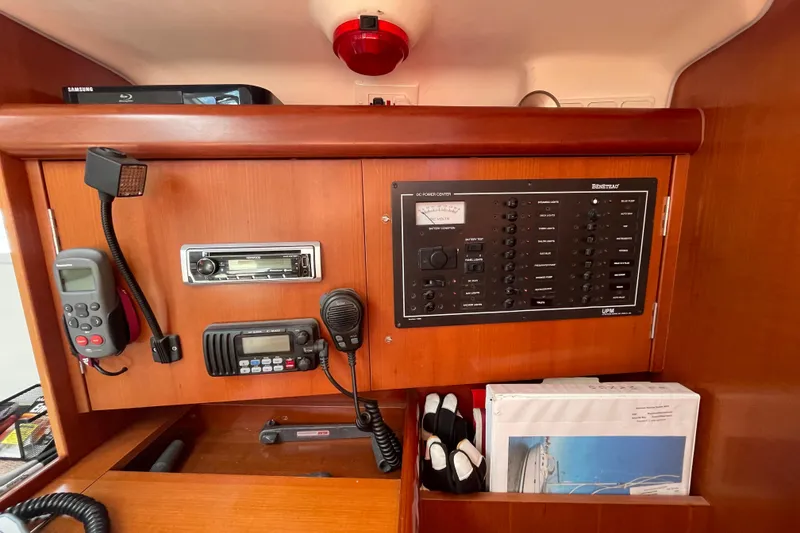 Slide: The Image of Nav station of a 2007 Beneteau 393 sailboat with communication equipment and manuals. - 5