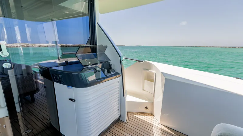 Slide: The Image of Flybridge Helm Station The flybridge helm station on the 2027 60 Absolute Flybridge offers a sleek and modern design, equipped with advanced navigation controls. The area features high-quality finishes and a panoramic view of the surrounding waters, enhancing the cruising exper - 6492515