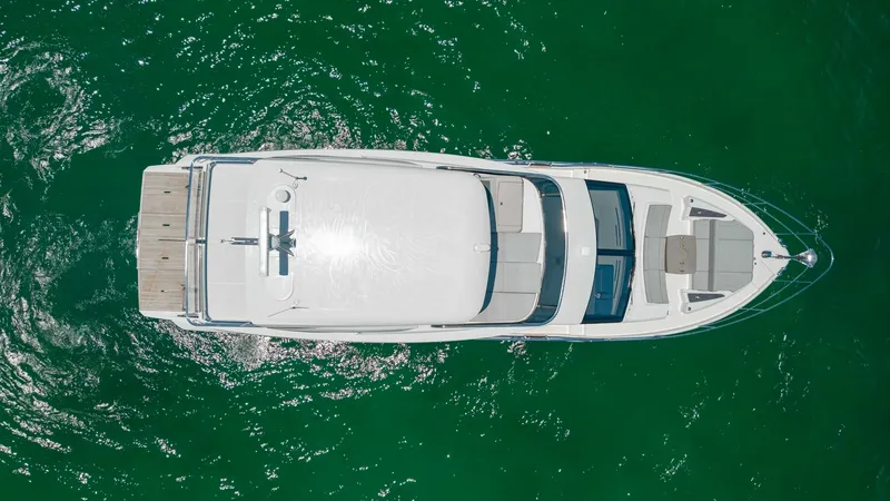 Slide: The Image of Aerial View of Flybridge and Deck This aerial shot of the 2027 Absolute 60 Flybridge showcases its sleek design and spacious layout. The flybridge features ample seating and a stylish helm, perfect for commanding views. The aft deck offers a generous area for relaxation, with seamless acc - 6492550