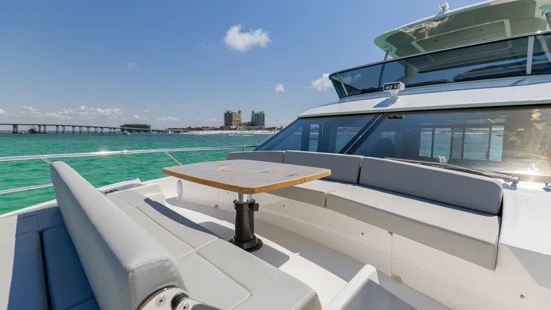 Slide: The Image of Flybridge Seating with Ocean Views This luxurious flybridge on the 2027 Absolute 60 Flybridge offers ample seating with plush, cushioned benches and a stylish central table. The area is perfect for socializing while enjoying panoramic ocean views. The sleek design and high-quality finishes - 6492520