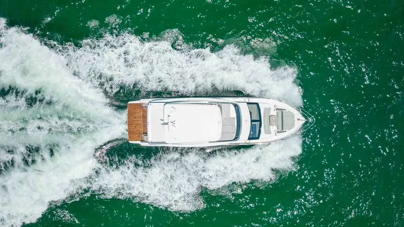 Slide: The Image of Aerial View of Flybridge and Deck This striking aerial shot showcases the spacious flybridge and deck of the 2027 60 Absolute Flybridge. The well-appointed layout features ample seating, perfect for entertaining or relaxing while cruising. The sleek design and elegant finishes are complem - 6492554