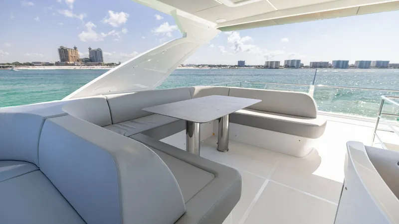 Slide: The Image of Flybridge Lounge with Panoramic Views The 2027 60 Absolute Flybridge features a spacious flybridge lounge designed for relaxation and entertainment. Highlighted by sleek, modern seating and a central dining table, this area offers panoramic views of the surrounding waters. The open-air design - 6492537