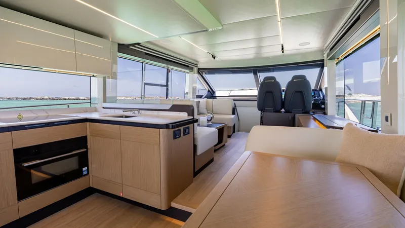 Slide: The Image of Spacious Main Deck Salon and Helm The main deck of the 2027 60 Absolute Flybridge features a luxurious salon with expansive windows, offering panoramic views. Elegant wood finishes and modern furnishings create a sophisticated ambiance, while the forward helm provides state-of-the-art nav - 6492482
