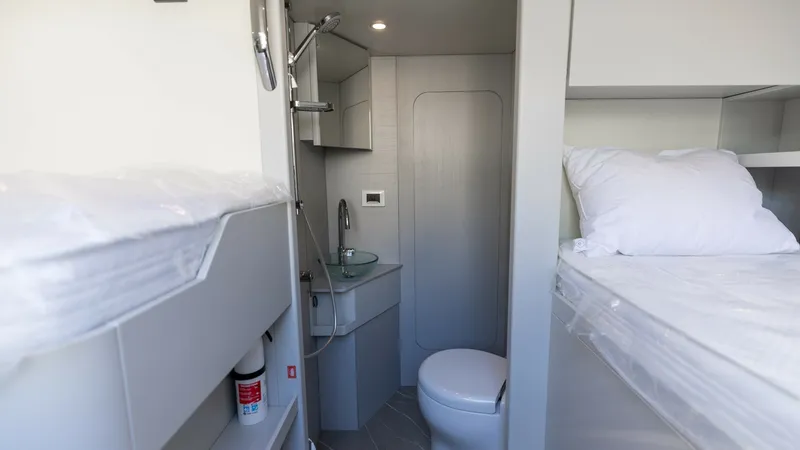 Slide: The Image of Compact Guest Cabin with Ensuite This cozy guest cabin on the 2027 Absolute 60 Flybridge features modern bunk beds and a compact ensuite bathroom. The room is designed with light tones and sleek finishes, enhancing the sense of space and comfort. Practical storage solutions and contempor - 6492542