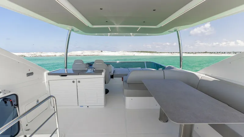 Slide: The Image of Spacious Flybridge with Seating Area The expansive flybridge of the 2027 60 Absolute Flybridge offers a luxurious open-air experience with panoramic ocean views. Featuring a comfortable seating area with plush cushions and a sleek dining table, it provides an ideal space for entertaining or - 6492524