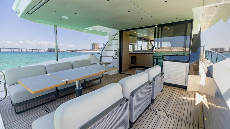 Slide: The Image of Spacious Aft Deck with Seating The aft deck of the 2027 Absolute 60 Flybridge offers ample seating with plush, modern cushions and a large dining table, perfect for entertaining. The sleek teak flooring complements the elegant design, while the open-air layout provides breathtaking vie - 6492508