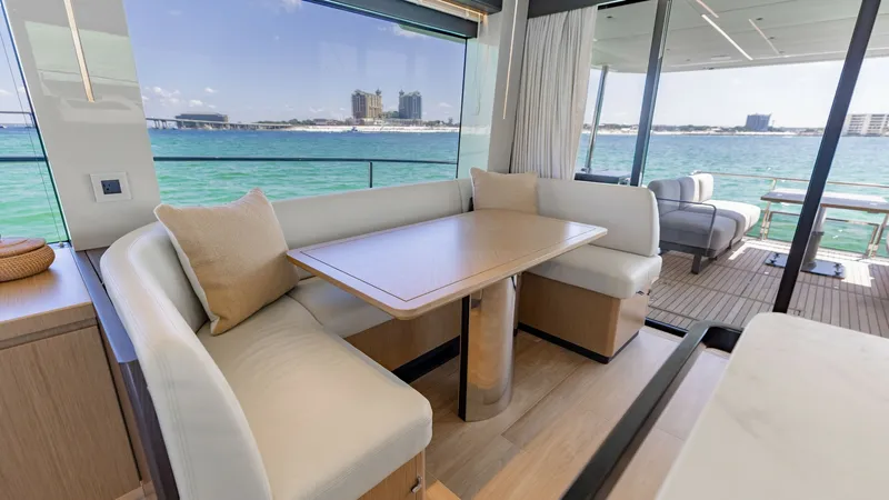 Slide: The Image of Flybridge Salon with Panoramic Views This spacious flybridge salon on the 2027 Absolute 60 Flybridge features elegant seating with plush cushions and a versatile dining table. Large windows offer stunning panoramic views of the surrounding waters, enhancing the open and airy ambiance. The se - 6492481