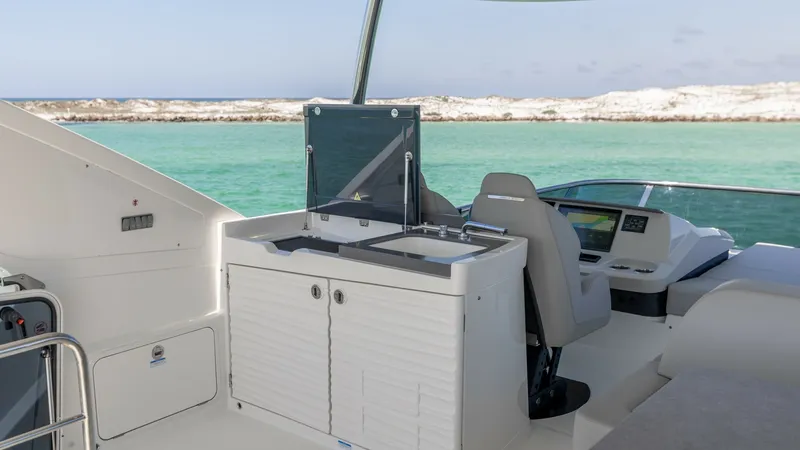 Slide: The Image of Flybridge Helm and Wet Bar The flybridge of the 2027 60 Absolute Flybridge showcases a sleek helm station with state-of-the-art navigation systems. Adjacent is a well-equipped wet bar, perfect for entertaining while enjoying panoramic ocean views. This area combines functionality w - 6492536