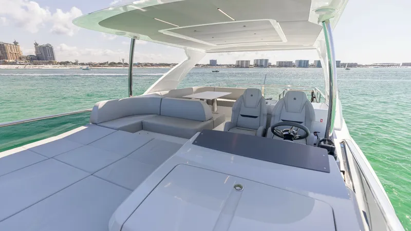 Slide: The Image of Spacious Flybridge with Helm Seating This image showcases the expansive flybridge of the 2027 60 Absolute Flybridge, featuring luxurious sunpads and sleek helm seating for two. The open layout offers ample space for relaxation and socializing, with modern design elements and panoramic views. - 6492531