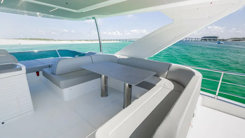 Slide: The Image of Flybridge Seating Area with Ocean View Experience luxury and comfort in the flybridge seating area of the 2027 Absolute 60 Flybridge. The spacious U-shaped lounge offers ample seating, perfect for entertaining or relaxing while enjoying panoramic ocean views. The sleek table and modern finishe - 6492525