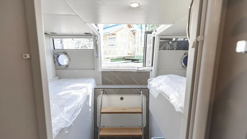 Slide: The Image of Twin Guest Cabin with Portlights This cozy twin guest cabin on the 2027 60 Absolute Flybridge features two comfortable single beds with modern bedding. The space is well-lit with natural light from the dual portlights, enhancing the airy ambiance. Elegant wood accents and sleek surfaces - 6492540