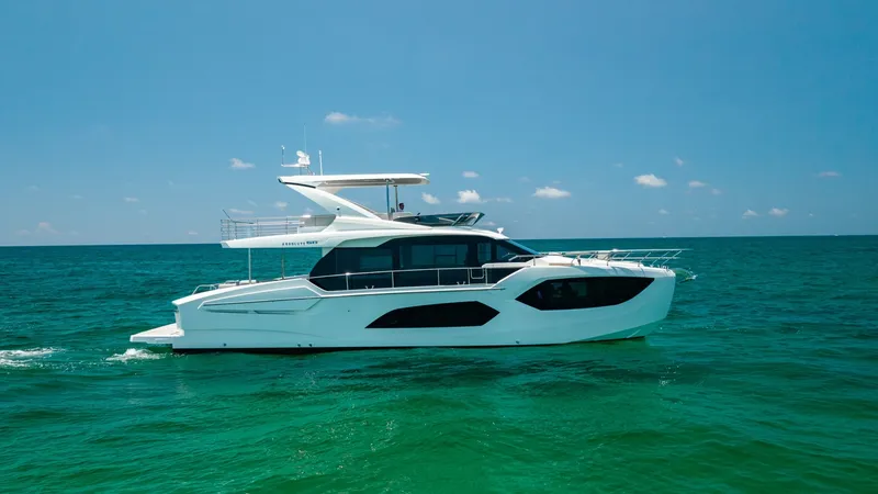 Slide: The Image of Side Profile of 60 Absolute Flybridge The 2027 60 Absolute Flybridge showcases a sleek, modern design with expansive windows and a streamlined hull. The flybridge offers ample space for relaxation and entertainment, complete with elegant railings and a shaded area. This vessel's elegant silho - 6492549