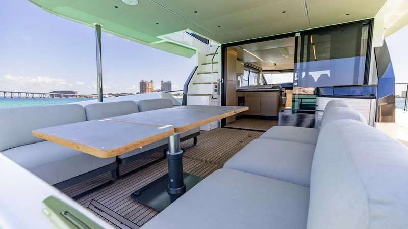 Slide: The Image of Spacious Aft Deck Lounge Area The aft deck of the 2027 Absolute 60 Flybridge offers a luxurious and spacious seating area with ample plush cushions. The large dining table is perfect for alfresco meals, surrounded by panoramic views of the sea. The seamless transition to the interior - 6492509