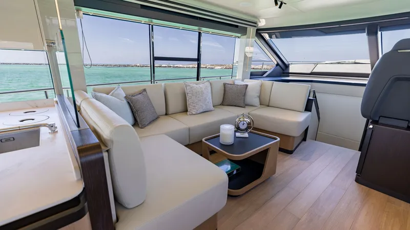 Slide: The Image of Spacious Interior Salon with Ocean Views The interior salon of the 2027 60 Absolute Flybridge offers a luxurious and inviting space with panoramic ocean views through expansive windows. The plush L-shaped seating is complemented by elegant cushions, creating a comfortable environment for relaxat - 6492483