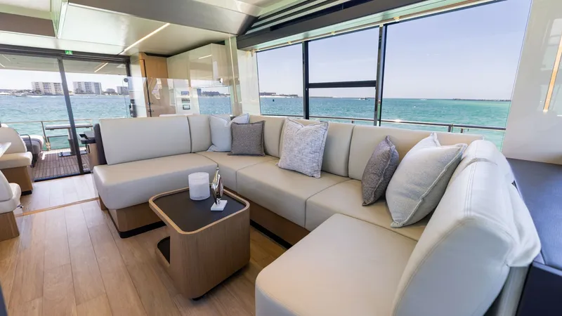 Slide: The Image of Spacious Salon with Panoramic Views The salon of the 2027 60 Absolute Flybridge offers a luxurious and inviting space with expansive windows that provide stunning panoramic views of the sea. The plush L-shaped seating is complemented by elegant wood flooring and modern decor, creating a per - 6492484