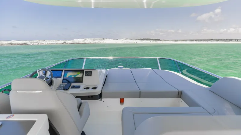 Slide: The Image of Flybridge Helm and Lounge Area The flybridge of the 2027 Absolute 60 Flybridge offers a spacious helm area equipped with state-of-the-art navigation technology. Adjacent to the helm, a luxurious lounge area provides ample seating, perfect for enjoying panoramic ocean views. The sleek d - 6492526