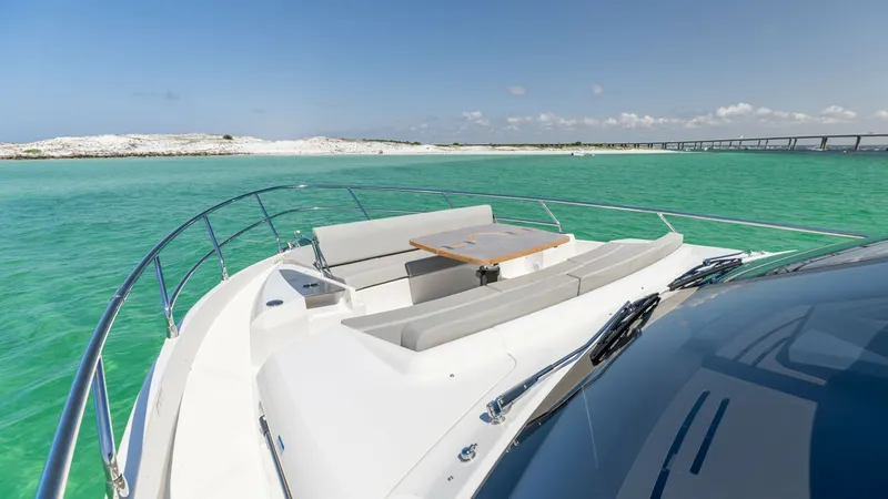 Slide: The Image of Spacious Bow Lounge Area The bow of the 2027 Absolute 60 Flybridge features a luxurious lounge area with plush seating and a stylish wooden table, perfect for socializing or relaxing. Surrounded by sleek stainless steel railings, this space offers breathtaking panoramic views of - 6492523