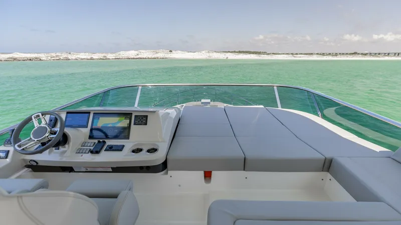 Slide: The Image of Flybridge Helm with Sunpad Lounge The flybridge of the 2027 Absolute 60 Flybridge offers a spacious helm station equipped with modern navigation systems and sleek controls. Adjacent to the helm, a luxurious sunpad lounge provides an ideal space for relaxation while enjoying panoramic view - 6492529