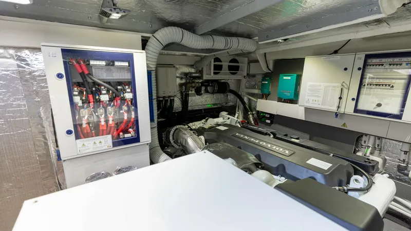 Slide: The Image of Engine Room with Electrical Systems The engine room of the 2027 Absolute 60 Flybridge showcases advanced engineering with a neatly organized layout. Featuring a powerful engine, state-of-the-art electrical panels, and efficient ventilation systems, this space is designed for optimal perform - 6492545