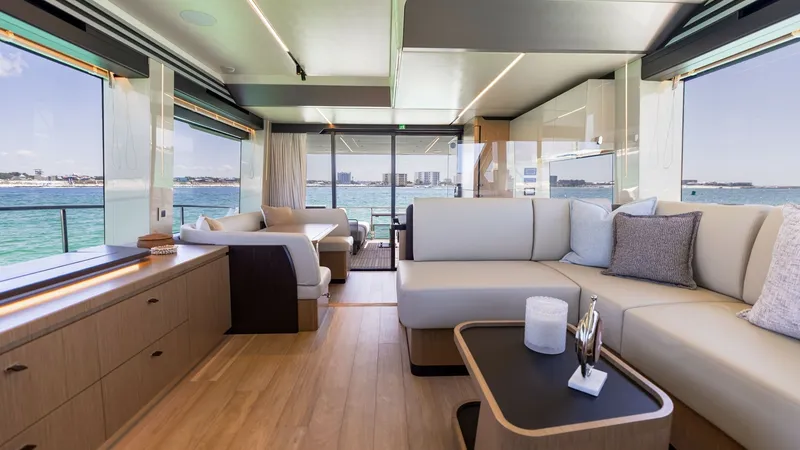 Slide: The Image of Spacious Salon with Panoramic Views This elegant salon on the 2027 Absolute 60 Flybridge offers a luxurious and open layout with ample natural light. The modern interior features plush seating and sleek wood finishes, creating an inviting atmosphere for relaxation and entertainment. Expansi - 6492477