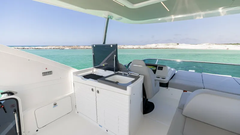 Slide: The Image of Flybridge Wet Bar with Ocean View The flybridge of the 2027 Absolute 60 Flybridge features a sleek wet bar equipped with a sink and ample storage, perfect for entertaining. Luxurious seating offers a comfortable space to relax while enjoying panoramic ocean views. The modern design and hi - 6492534