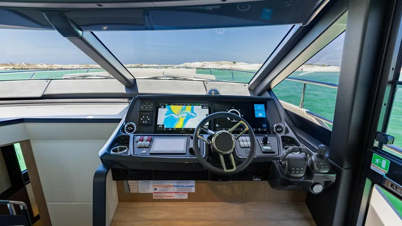 Slide: The Image of Flybridge Helm Station The helm station on the 2027 Absolute 60 Flybridge features state-of-the-art navigation technology, including a sleek touchscreen display and ergonomic controls. The expansive windshield offers a panoramic view, enhancing both visibility and safety. Luxur - 6492490