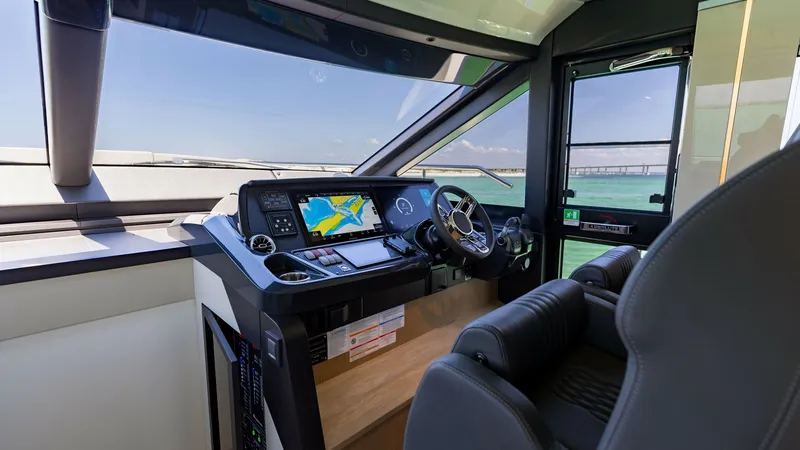 Slide: The Image of Flybridge Helm Station The helm station of the 2027 60 Absolute Flybridge offers advanced navigation technology with dual displays for comprehensive control. The ergonomic captain's seat and intuitive layout ensure a comfortable and commanding experience. Expansive windows prov - 6492488