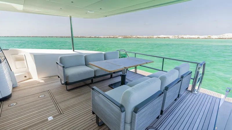 Slide: The Image of Spacious Aft Deck with Seating The aft deck of the 2027 Absolute 60 Flybridge offers an inviting space with a large, comfortable seating area perfect for social gatherings. The teak flooring adds a touch of elegance, while the panoramic views of the water enhance the outdoor experience - 6492511