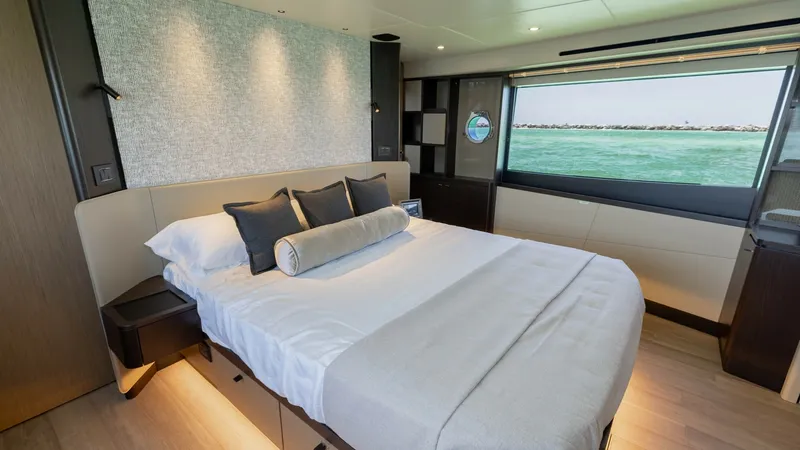 Slide: The Image of Luxurious Master Stateroom The master stateroom of the 2027 60 Absolute Flybridge offers a luxurious retreat with a plush double bed and elegant bedding. Large windows provide stunning ocean views, enhancing the serene atmosphere. The room features modern lighting and sophisticated - 6492491