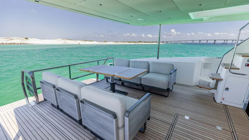 Slide: The Image of Spacious Aft Deck with Seating The aft deck of the 2027 Absolute 60 Flybridge offers a luxurious outdoor seating area perfect for entertaining. Featuring plush, comfortable cushions and a stylish teak table, this space provides an ideal setting for alfresco dining or relaxing with pano - 6492512