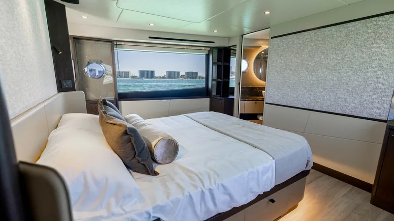 Slide: The Image of Master Stateroom with Ocean View The master stateroom of the 2027 60 Absolute Flybridge offers luxurious comfort with a spacious layout. It features a plush double bed, contemporary finishes, and ample natural light from large windows that provide stunning ocean views. The room's elegant - 6492492