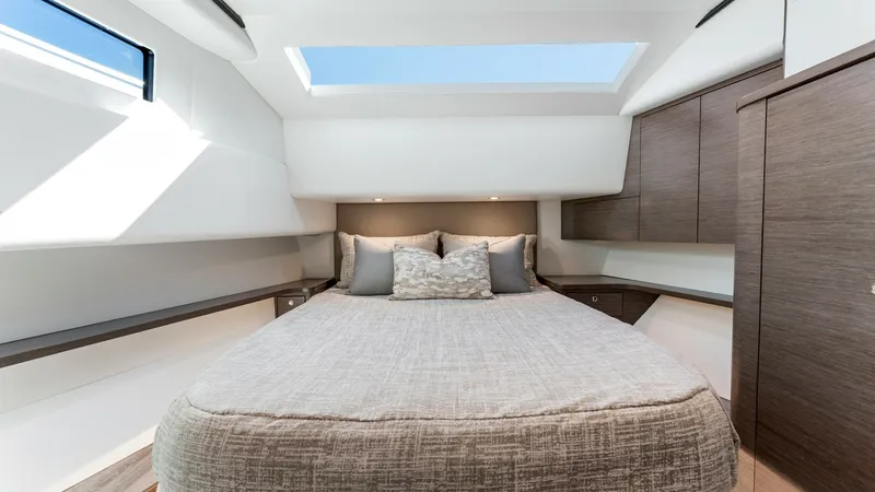 Slide: The Image of Luxurious Forward Stateroom Interior - Valhalla 55 Sport Yacht Experience ultimate comfort in the forward stateroom of the 2027 Valhalla Boatworks 55 SY. This space features a plush double berth, complemented by sleek cabinetry and ample natural light from the overhead skylight. The modern design and high-quality fin - 6332935