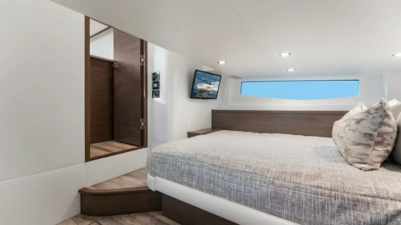 Slide: The Image of Spacious Forward Stateroom - Valhalla 55 Sport Yacht This forward stateroom on the 2027 Valhalla Boatworks 55 SY offers a serene retreat with its sleek, modern design. The room features a comfortable double bed, accentuated by soft ambient lighting and large windows that provide ample natural light. Rich wo - 6332939